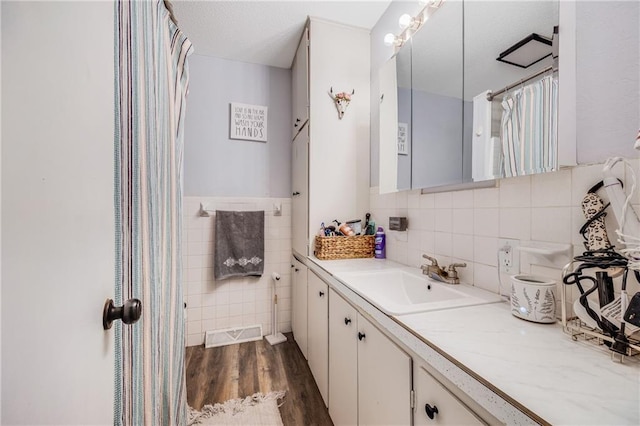 312 W Pine St, Butler, MO 64730 - bathroom featuring tile walls, wood finished floors, and vanity