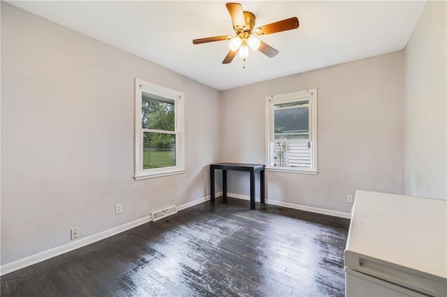312 W Pine St, Butler, MO 64730 - unfurnished room featuring baseboards, dark wood-style flooring, and a ceiling fan