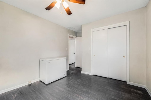 312 W Pine St, Butler, MO 64730 - unfurnished bedroom with fridge, dark wood-type flooring, baseboards, a closet, and ceiling fan