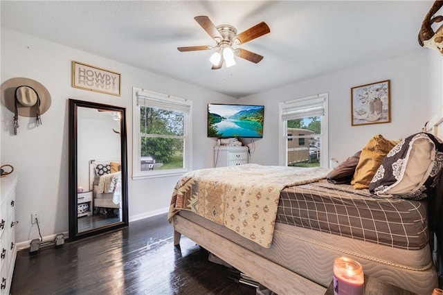 312 W Pine St, Butler, MO 64730 - bedroom with multiple windows, dark wood-style flooring, baseboards, and a ceiling fan