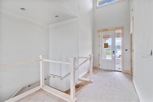 entrance foyer featuring baseboards and a towering ceiling