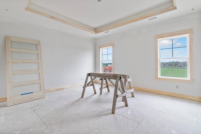 dining space with a tray ceiling and baseboards