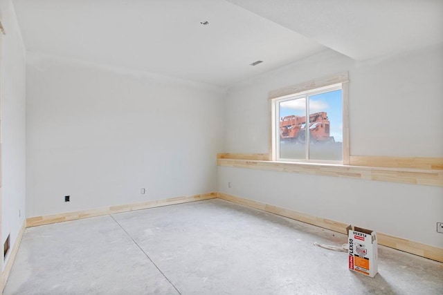 empty room with concrete floors and baseboards