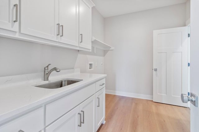 1811 Halls Creek Ave, Raymore, MO 64083 - laundry room with washer hookup, light wood finished floors, and cabinet space