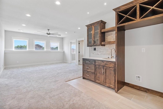 1811 Halls Creek Ave, Raymore, MO 64083 - kitchen with recessed lighting, ceiling fan, backsplash, dark brown cabinets, and light countertops