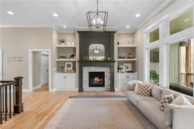 5566 Thousand Oaks Dr, Parkville, MO 64152 - living area featuring an inviting chandelier, light wood-type flooring, recessed lighting, ornamental molding, and a stone fireplace