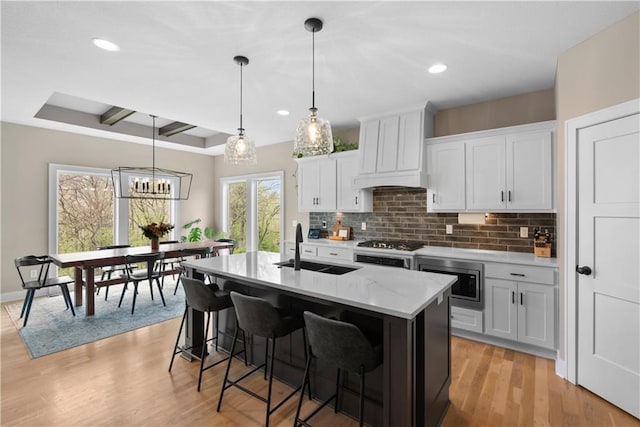 5566 Thousand Oaks Dr, Parkville, MO 64152 - kitchen featuring stainless steel microwave, a sink, decorative backsplash, and custom exhaust hood