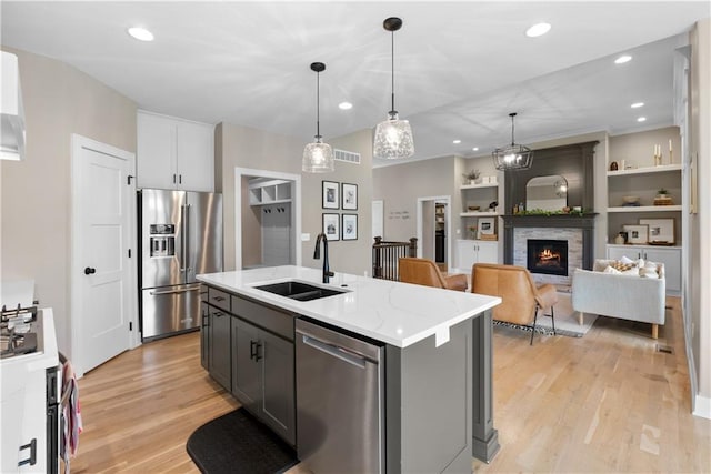 5566 Thousand Oaks Dr, Parkville, MO 64152 - kitchen with a sink, appliances with stainless steel finishes, visible vents, light wood-type flooring, and decorative light fixtures