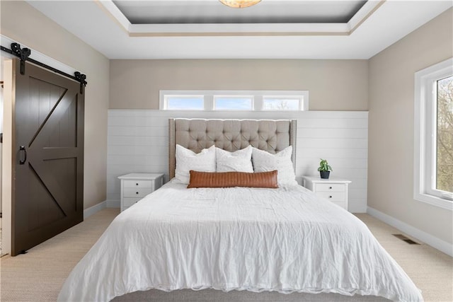 5566 Thousand Oaks Dr, Parkville, MO 64152 - bedroom with a barn door, multiple windows, light colored carpet, and a tray ceiling