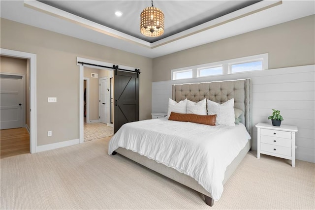 5566 Thousand Oaks Dr, Parkville, MO 64152 - bedroom featuring a barn door, a tray ceiling, baseboards, an inviting chandelier, and light carpet