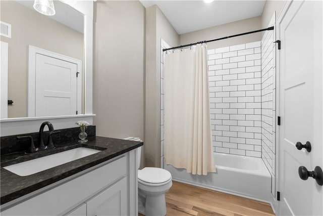 5566 Thousand Oaks Dr, Parkville, MO 64152 - full bath with wood finished floors, shower / bath combo, toilet, vanity, and visible vents