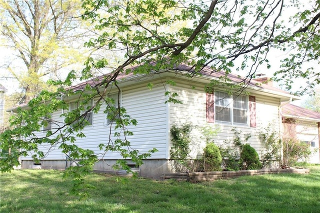 view of property exterior with a lawn and a chimney