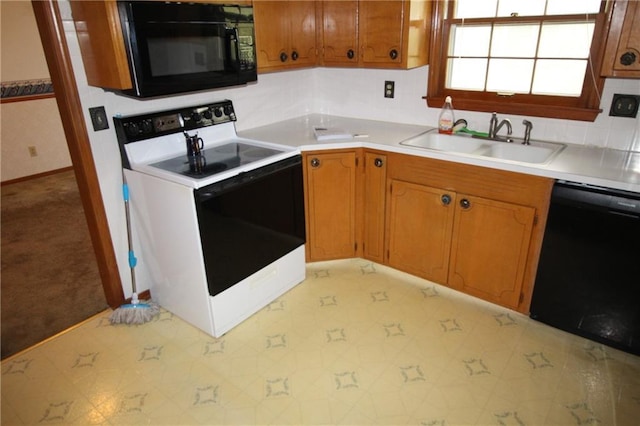kitchen featuring baseboards, light countertops, brown cabinets, a sink, and black appliances