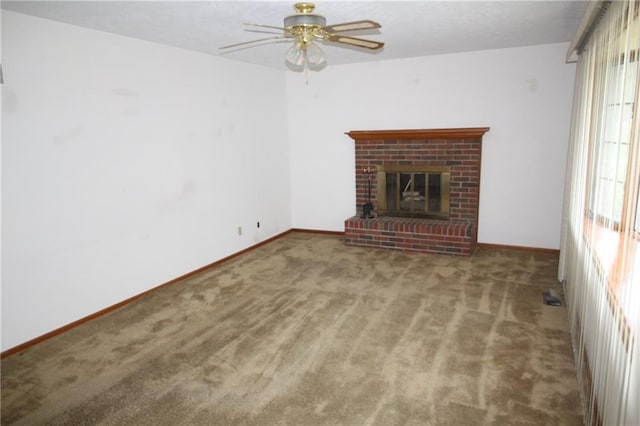 unfurnished living room with baseboards, a fireplace, a ceiling fan, and carpet flooring