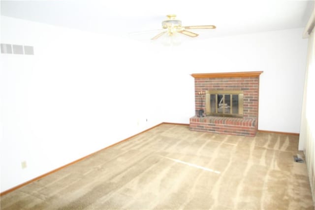 unfurnished living room featuring ceiling fan, a fireplace, carpet flooring, and visible vents