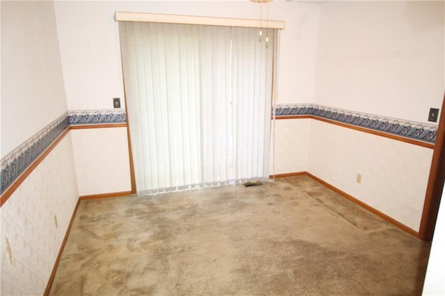empty room featuring baseboards, carpet flooring, and wallpapered walls