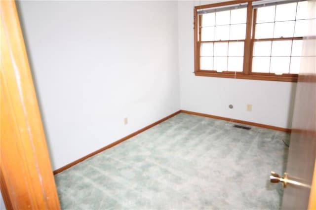 carpeted spare room with baseboards and visible vents