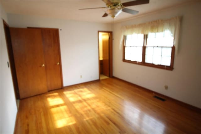 unfurnished bedroom with light wood-style floors, baseboards, a closet, and visible vents