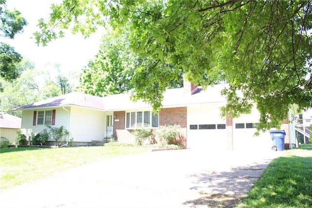 1211 Spruce St, Eudora, KS 66025 - single story home featuring asphalt driveway, a garage, brick siding, a chimney, and a front lawn