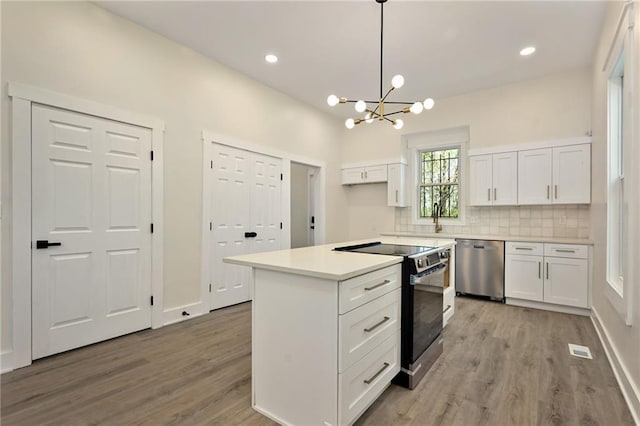 kitchen with white cabinets, light wood-style flooring, electric range, a notable chandelier, and dishwasher