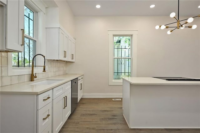 kitchen with stainless steel dishwasher, an inviting chandelier, a sink, and plenty of natural light