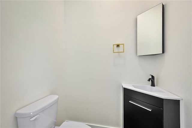 half bath featuring vanity and toilet