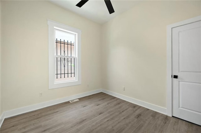 unfurnished room featuring baseboards, a ceiling fan, and wood finished floors