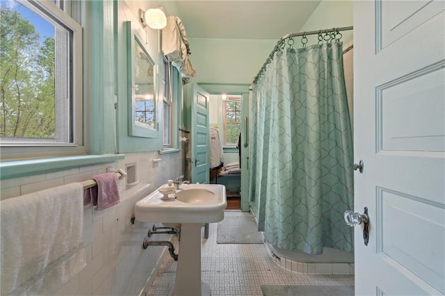 full bath with curtained shower, a wealth of natural light, and tile patterned floors