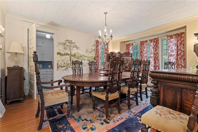 dining room featuring wood finished floors, an inviting chandelier, and ornamental molding