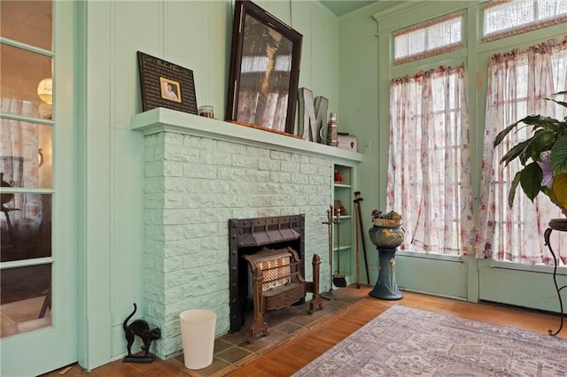 living area featuring plenty of natural light, wood finished floors, and ornamental molding