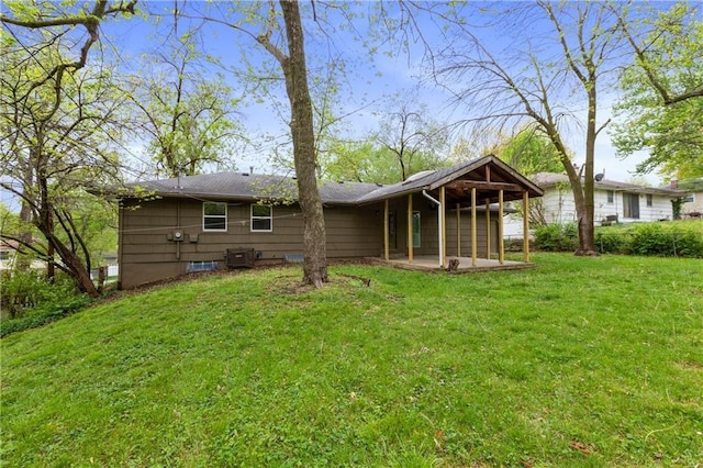 rear view of property featuring a yard and a patio area