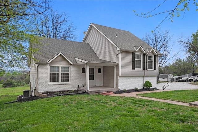 28274 W 311th St, Paola, KS 66071 - split level home featuring brick siding, a front yard, covered porch, and roof with shingles
