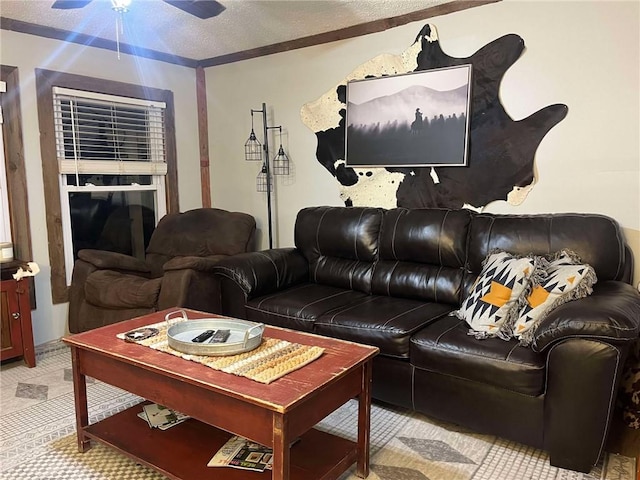 living room with a ceiling fan and a textured ceiling