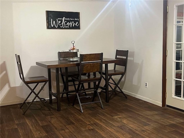 dining space featuring dark wood-style flooring and baseboards