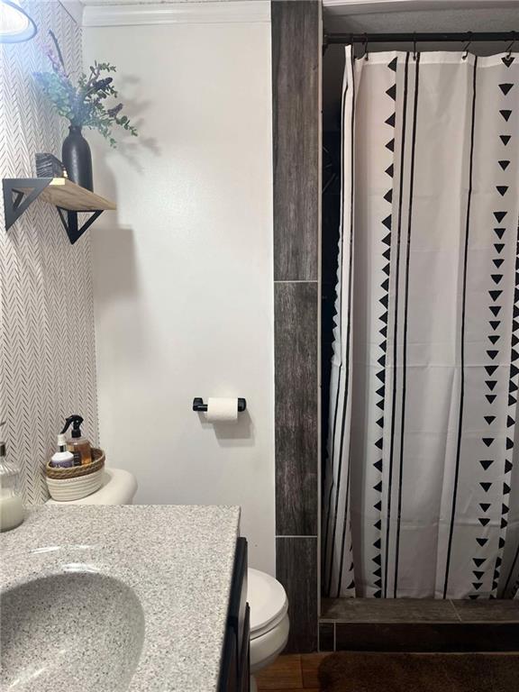 full bath featuring curtained shower, toilet, and vanity