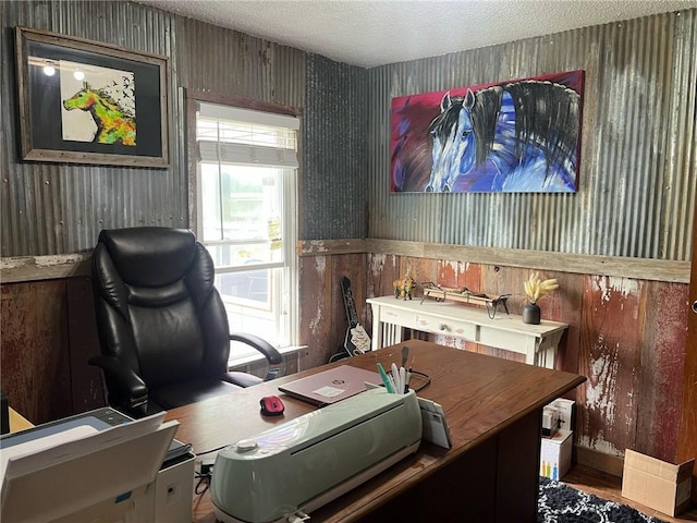 home office with wood walls, a textured ceiling, and wood finished floors