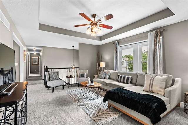 12200 E 214th Ter, Peculiar, MO 64078 - living room with carpet floors, a raised ceiling, a ceiling fan, and baseboards