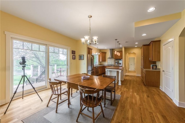 8725 Nebo Hills Rd, Liberty, MO 64068 - dining space featuring arched walkways, baseboards, an inviting chandelier, and light wood-style flooring