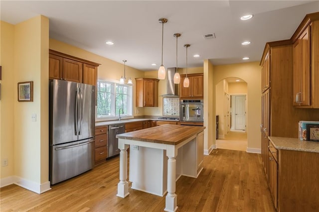 8725 Nebo Hills Rd, Liberty, MO 64068 - kitchen featuring wall chimney range hood, brown cabinets, a sink, wooden counters, and stainless steel appliances