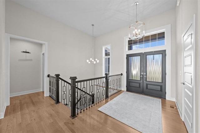 6309 NW 58th Ter, Kansas City, MO 64151 - entryway featuring french doors, visible vents, baseboards, a chandelier, and wood finished floors