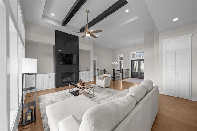 6309 NW 58th Ter, Kansas City, MO 64151 - living room featuring recessed lighting, wood finished floors, a large fireplace, and ceiling fan with notable chandelier