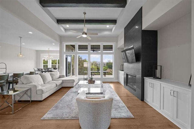 6309 NW 58th Ter, Kansas City, MO 64151 - living area with recessed lighting, light wood-style floors, ceiling fan with notable chandelier, a high ceiling, and a tile fireplace