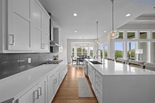 6309 NW 58th Ter, Kansas City, MO 64151 - kitchen featuring a sink, tasteful backsplash, recessed lighting, stainless steel gas stovetop, and wall chimney range hood
