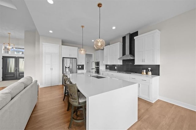 6309 NW 58th Ter, Kansas City, MO 64151 - kitchen featuring wall chimney exhaust hood, a sink, open floor plan, backsplash, and a breakfast bar