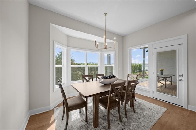 6309 NW 58th Ter, Kansas City, MO 64151 - dining room with baseboards, wood finished floors, and a chandelier