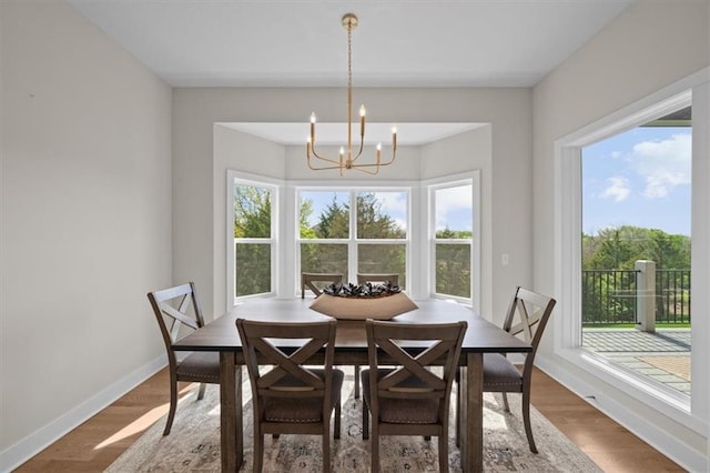 6309 NW 58th Ter, Kansas City, MO 64151 - dining area featuring a chandelier, wood finished floors, and baseboards