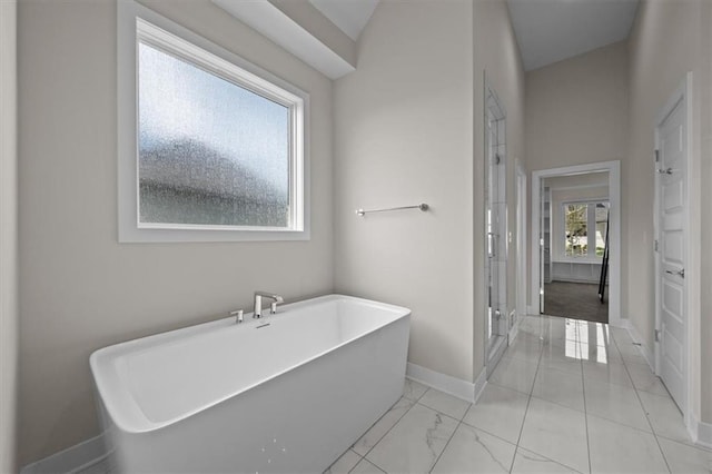6309 NW 58th Ter, Kansas City, MO 64151 - full bathroom featuring baseboards, a freestanding tub, marble finish floor, and a shower stall