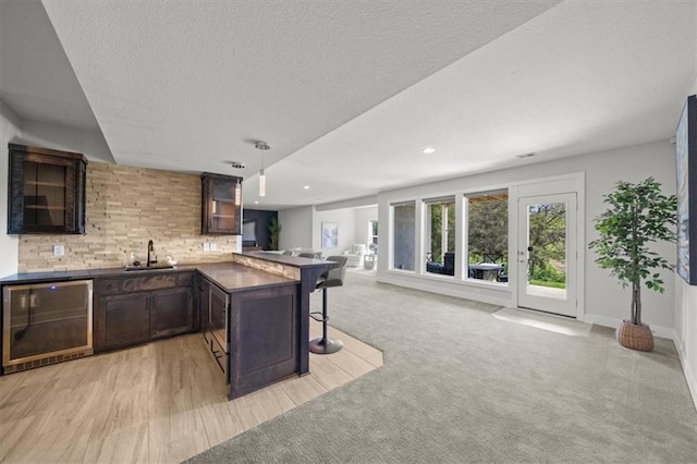 6309 NW 58th Ter, Kansas City, MO 64151 - kitchen with a sink, open floor plan, beverage cooler, a breakfast bar, and a peninsula