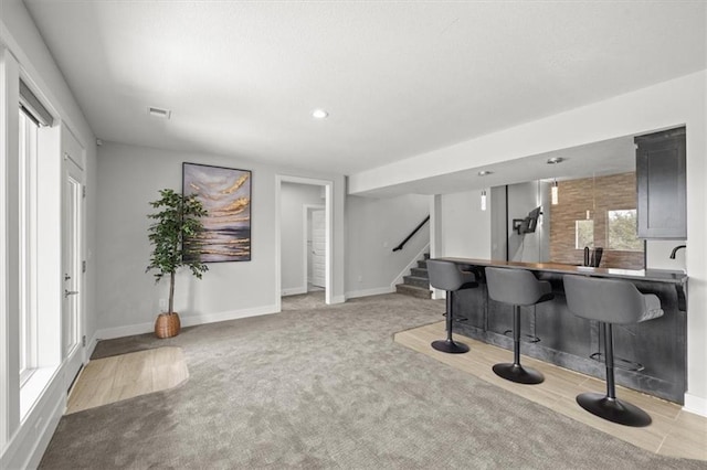 6309 NW 58th Ter, Kansas City, MO 64151 - bar with baseboards, stairs, and carpet floors