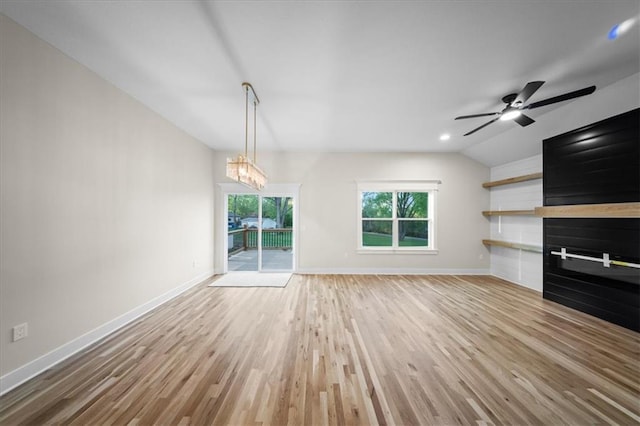 unfurnished living room with baseboards, light wood finished floors, vaulted ceiling, ceiling fan, and a chandelier